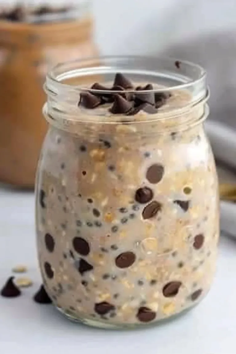 Bowl of protein-packed chocolate overnight oats topped with fresh berries.